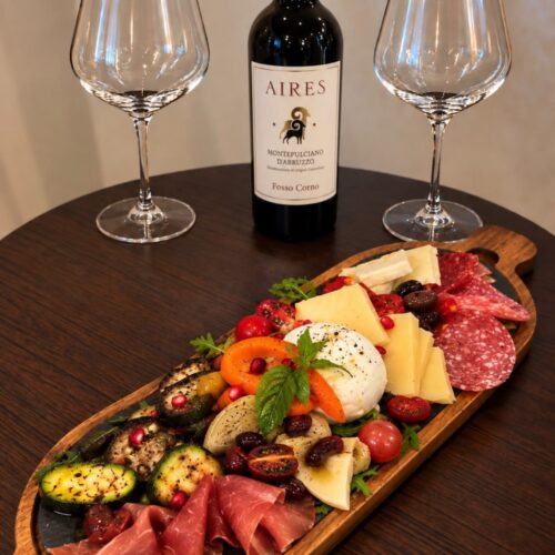 Antipasti-Platte mit Käse, Schinken, Gemüse und Rotwein im Il Salotto